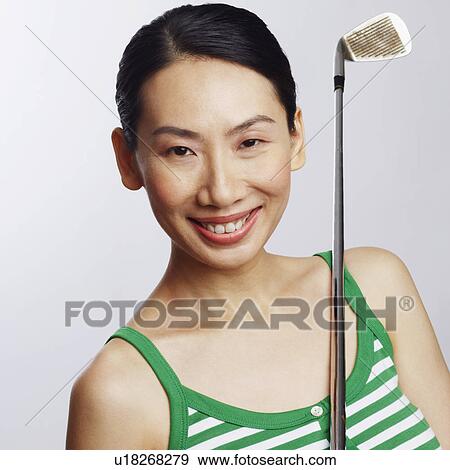 Portrait of a mid adult woman holding a golf club and smiling View Large Photo Image Stock Photo - Portrait of a mid adult woman holding a golf club and smiling. Fotosearch