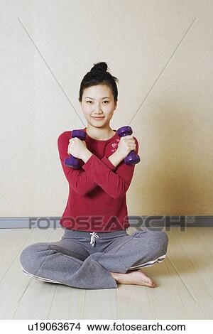 Portrait of a young woman exercising with dumbbells View Large Photo Image Picture - Portrait of a young woman exercising with dumbbells. Fotosearch