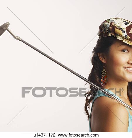 Portrait of a young woman holding a golf club and smiling View Large Photo Image Stock Image - Portrait of a young woman holding a golf club and smiling. Fotosearch