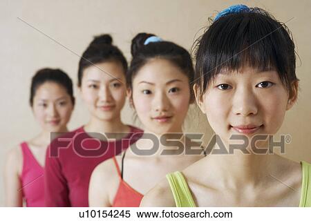 Stock Photography - Portrait of four young women in a row. Fotosearch