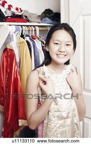 Stock Image - Portrait of a girl holding a dress. Fotosearch