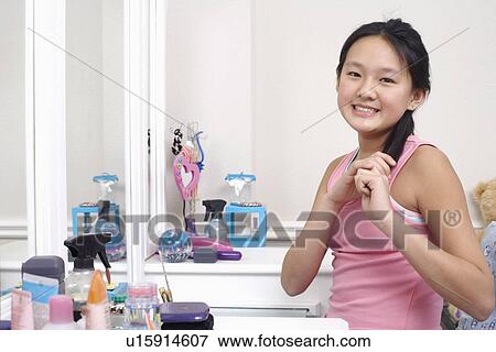 Stock Photo - Portrait of a girl holding her hair. Fotosearch