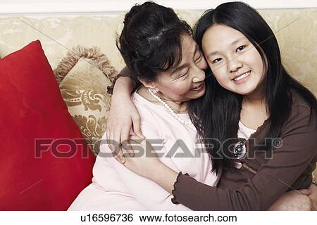 Stock Photograph - Portrait of a girl hugging her grandmother. Fotosearch