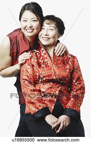Stock Image - Portrait of a girl standing behind her mother. Fotosearch