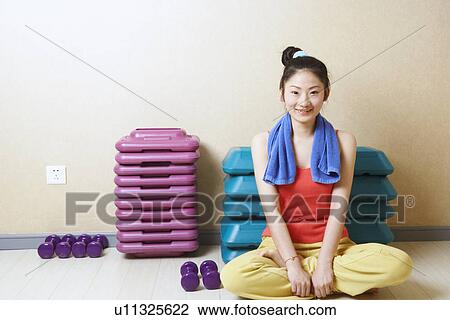 Stock Image - Portrait of a teenage girl sitting in front of stack of aerobic steps. Fotosearch