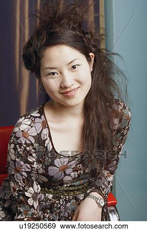 Portrait of a teenage girl sitting on a chair smiling View Large Photo Image Stock Photo - Portrait of a teenage girl sitting on a chair smiling. Fotosearch