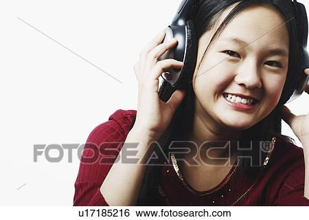 Stock Photograph - Portrait of a teenage girl wearing headphones listening to music. Fotosearch