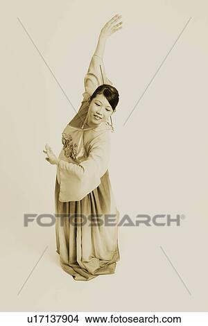 Picture - Close-up of a young woman wearing traditional clothing and dancing. Fotosearch