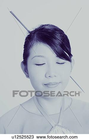 Stock Image - Close-up of a young woman wearing traditional clothing. Fotosearch