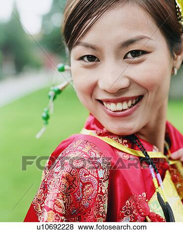 Portrait of a young woman in the traditional clothing smiling View Large Photo Image Stock Photo - Portrait of a young woman in the traditional clothing smiling. Fotosearch