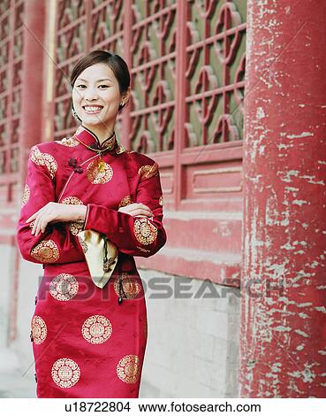 Picture - Portrait of a young woman standing in the traditional clothing and smiling. Fotosearch