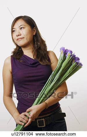 Close-up of a young woman holding a bouquet of flowers View Large Photo Image Picture - Close-up of a young woman holding a bouquet of flowers. Fotosearch