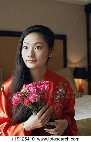 Close-up of a young woman holding a bunch of flowers View Large Photo Image Stock Image - Close-up of a young woman holding a bunch of flowers. Fotosearch