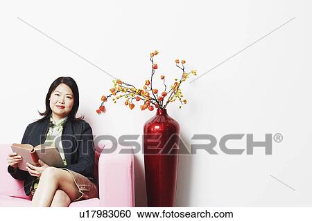 Portrait of a mid adult woman holding a book View Large Photo Image Stock Image - Portrait of a mid adult woman holding a book. Fotosearch