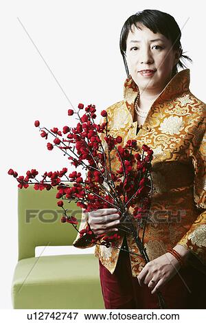 Stock Photo - Portrait of a mid adult woman holding flowers. Fotosearch