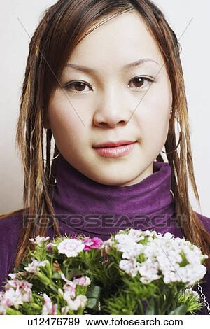 Stock Photo - Portrait of a young woman holding a bouquet of flowers. Fotosearch