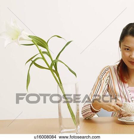Portrait of a young woman holding a tea cup and smiling View Large Photo Image Picture - Portrait of a young woman holding a tea cup and smiling. Fotosearch