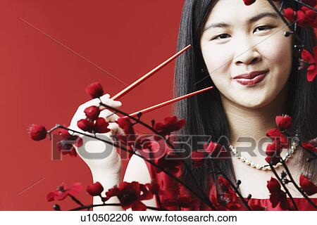 Portrait of a young woman holding chopsticks View Large Photo Image Stock Photograph - Portrait of a young woman holding chopsticks. Fotosearch