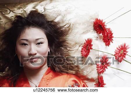 Stock Photograph - Portrait of a young woman lying on her back. Fotosearch