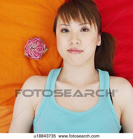 Stock Photography - Portrait of a young woman lying on the bed. Fotosearch