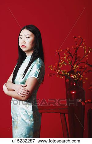 Portrait of a young woman standing near a flower pot View Large Photo Image Stock Photo - Portrait of a young woman standing near a flower pot. Fotosearch