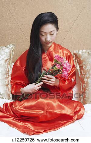 Stock Photograph - Young woman holding a bunch of flowers. Fotosearch