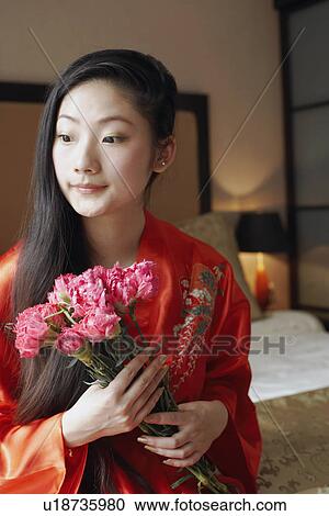 Close-up of a young woman holding a bunch of flowers View Large Photo Image Stock Image - Close-up of a young woman holding a bunch of flowers. Fotosearch