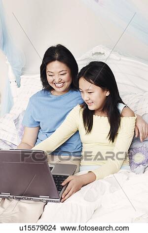 Picture - High angle view of a mother and her daughter using a laptop. Fotosearch