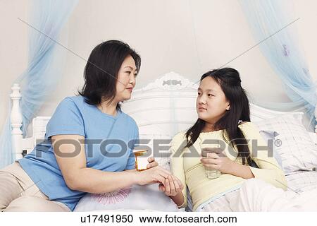Mother giving her daughter medicine View Large Photo Image Stock Image - Mother giving her daughter medicine. Fotosearch