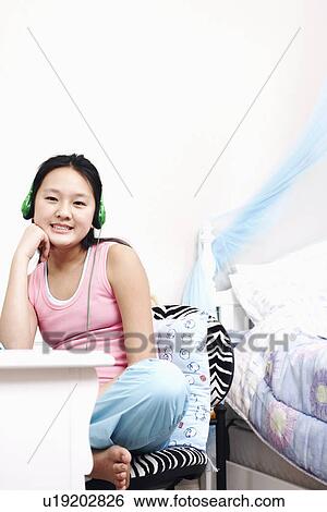 Portrait of a girl wearing headphones listening to music View Large Photo Image Stock Photograph - Portrait of a girl wearing headphones listening to music. Fotosearch