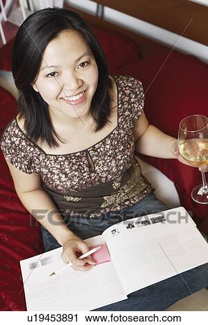 Portrait of a young woman holding a wineglass smiling View Large Photo Image Stock Image - Portrait of a young woman holding a wineglass smiling. Fotosearch