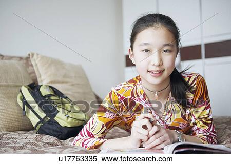 Stock Photography - Portrait of a young woman lying on the bed. Fotosearch