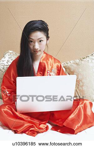 Portrait of a young woman using a laptop View Large Photo Image Stock Photography - Portrait of a young woman using a laptop. Fotosearch