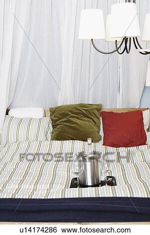 Stock Photograph - Wine glasses with a wine bottle on the bed. Fotosearch