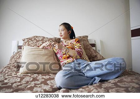 Stock Photo - Young woman listening to music. Fotosearch