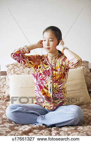 Young woman listening to music View Large Photo Image Stock Photo - Young woman listening to music. Fotosearch