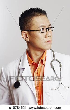 Close-up of a male doctor looking sideways and thinking View Large Photo Image Stock Image - Close-up of a male doctor looking sideways and thinking. Fotosearch