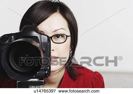 Close-up of a young woman taking a photograph View Large Photo Image Stock Photo - Close-up of a young woman taking a photograph. Fotosearch