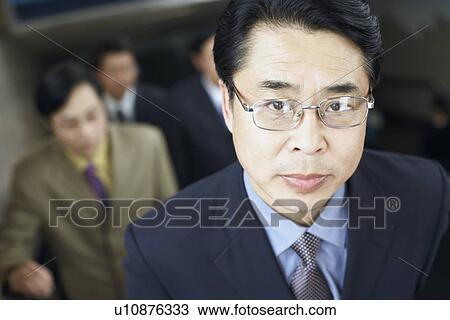 Stock Image - Portrait of a businessman on an escalator. Fotosearch