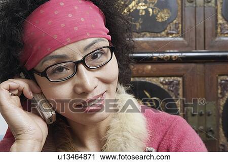 Stock Image - Portrait of a mature woman talking on a mobile phone. Fotosearch