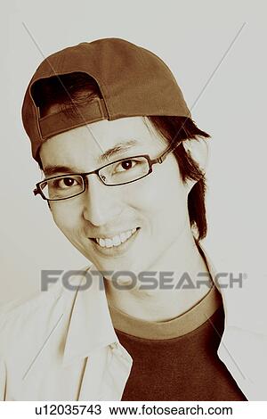 Stock Image - Portrait of a mid adult man smiling and wearing eyeglasses. Fotosearch