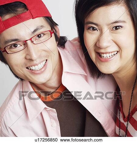 Portrait of a young woman and a mid adult man smiling View Large Photo Image Stock Image - Portrait of a young woman and a mid adult man smiling. Fotosearch