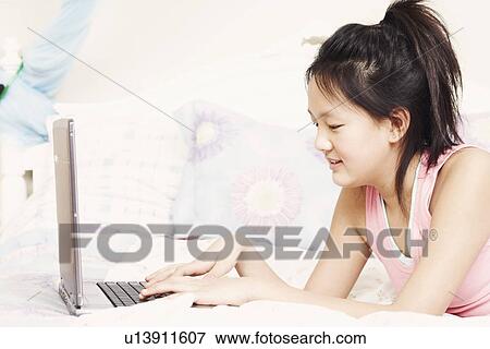 Close-up of a girl using a laptop View Large Photo Image Stock Photo - Close-up of a girl using a laptop. Fotosearch