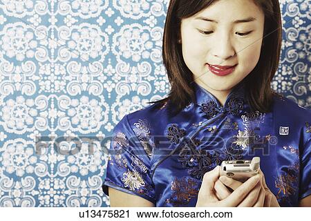 Stock Image - Close-up of a young woman holding a mobile phone. Fotosearch