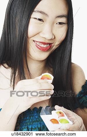 Stock Image - Close-up of a young woman holding a candy box. Fotosearch