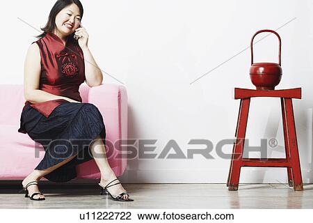Stock Image - Mid adult woman talking on a mobile phone. Fotosearch