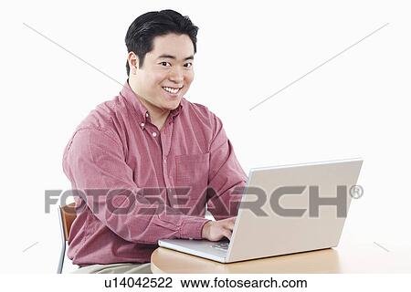 Stock Image - Portrait of a businessman using a laptop. Fotosearch