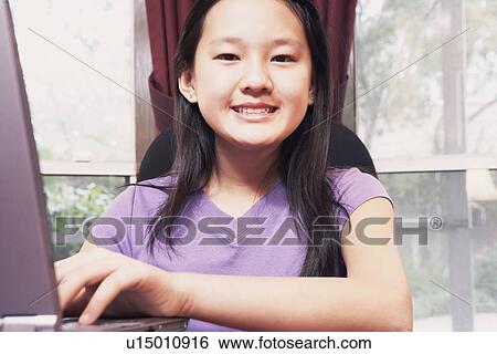 Portrait of a girl using a laptop View Large Photo Image Stock Photograph - Portrait of a girl using a laptop. Fotosearch
