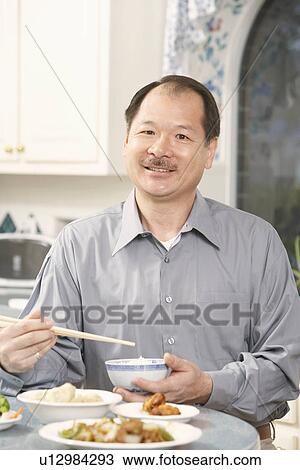Portrait of a senior man holding a bowl with a pair of chopsticks View Large Photo Image Stock Image - Portrait of a senior man holding a bowl with a pair of chopsticks. Fotosearch