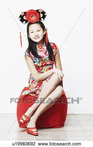 Stock Image - Portrait of a teenage girl sitting on a stool. Fotosearch